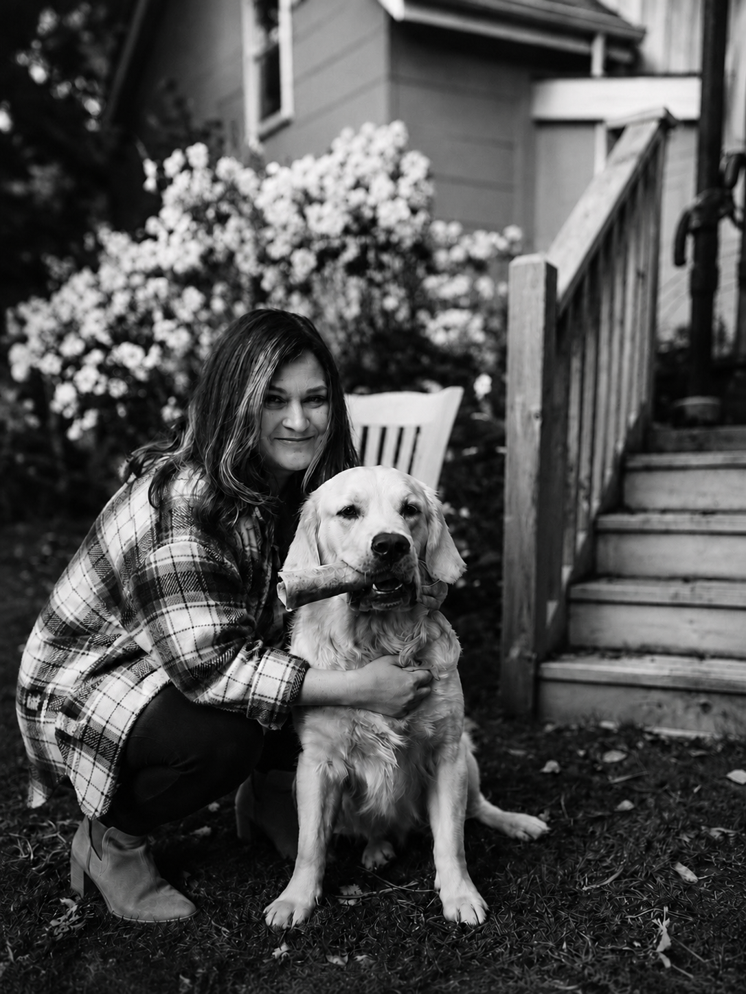 Amy Tremblay, Registered Psychotherapist in Owen Sound, with her golden retriever in a garden.