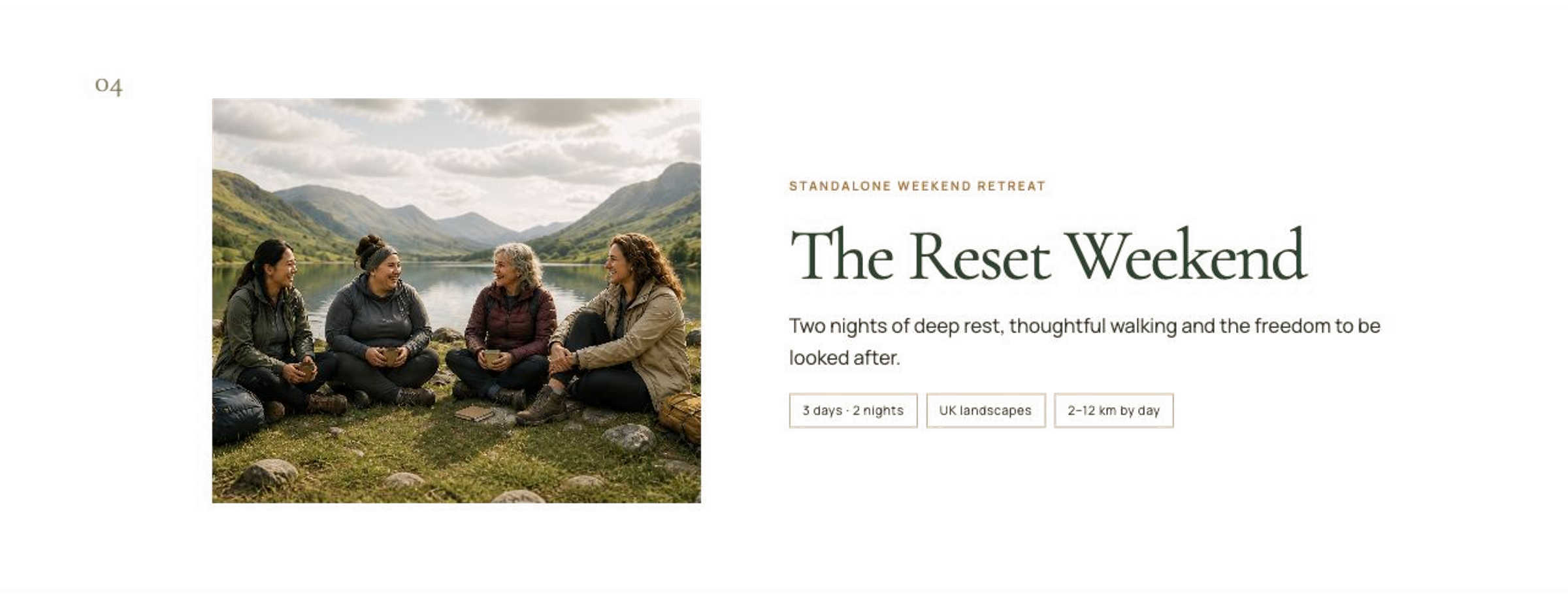 Four women sitting by a lake in green hills, smiling and talking during daytime.