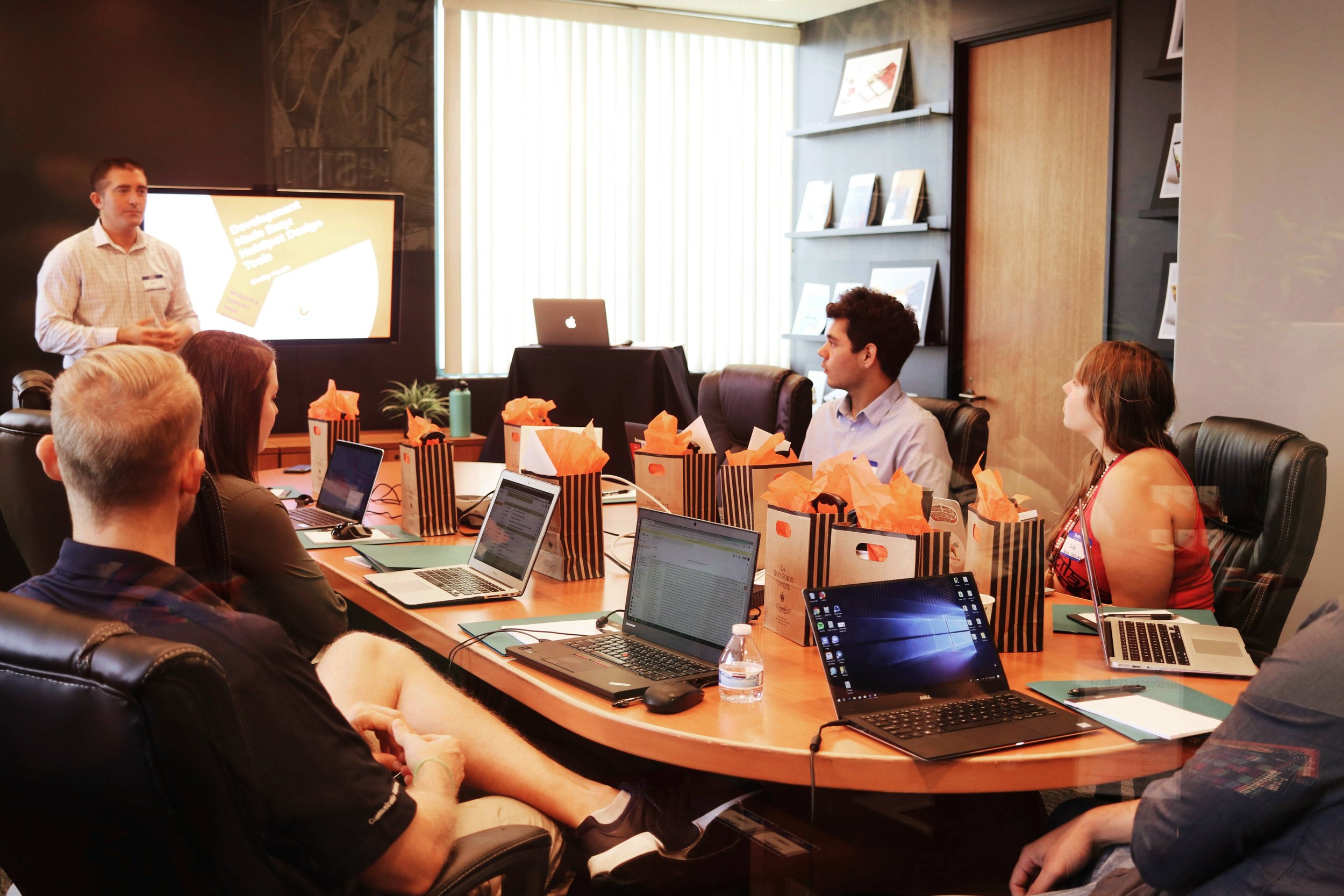 Team gathers around a table for a presentation.