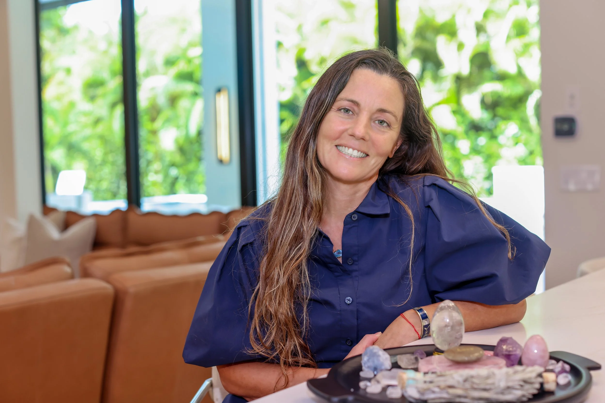 Dr. Dawn Murrin seated at a table with a tray of healing crystals