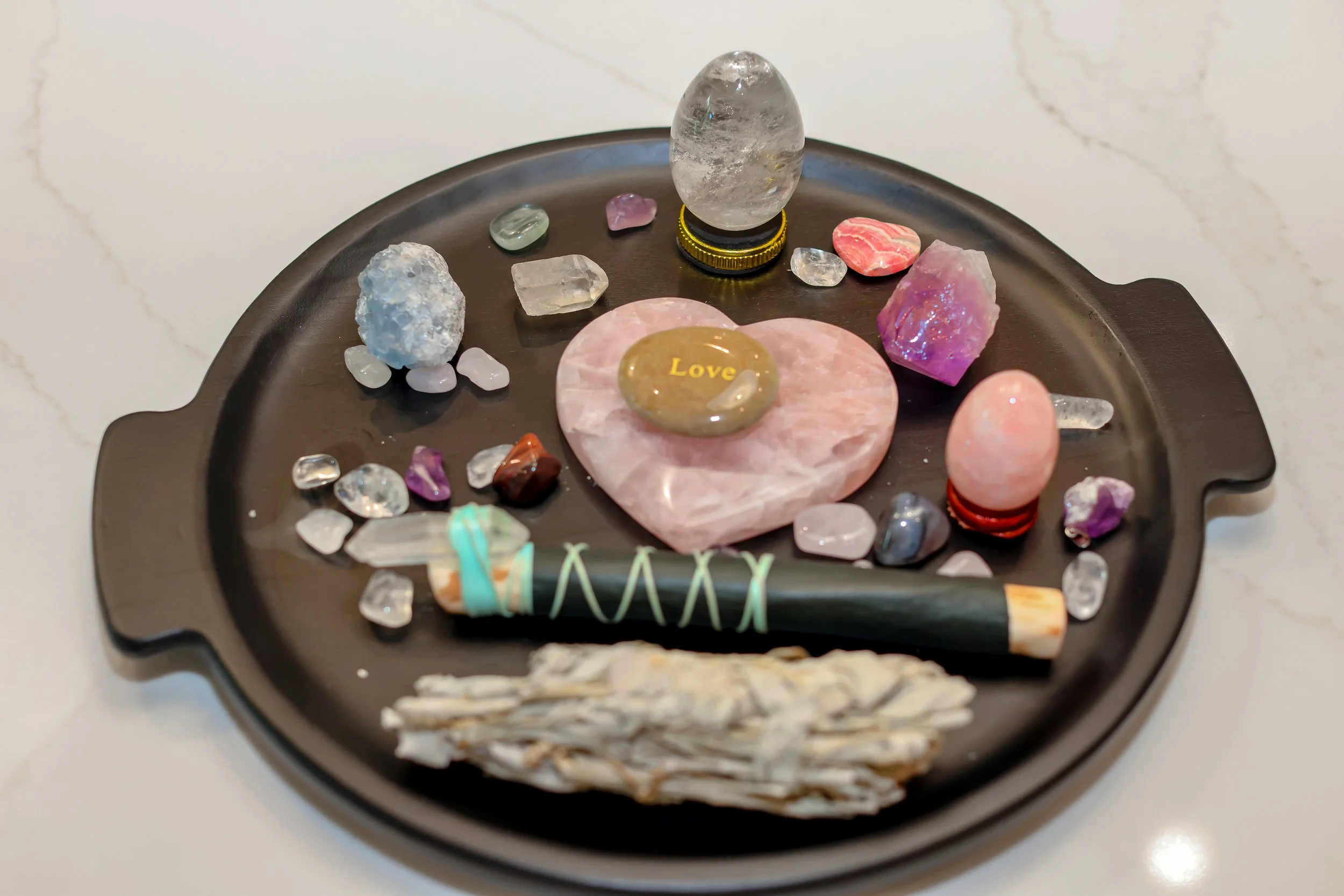 Crystal healing tray with a rose quartz heart, sage bundle and shamanic wand used in Life Activation