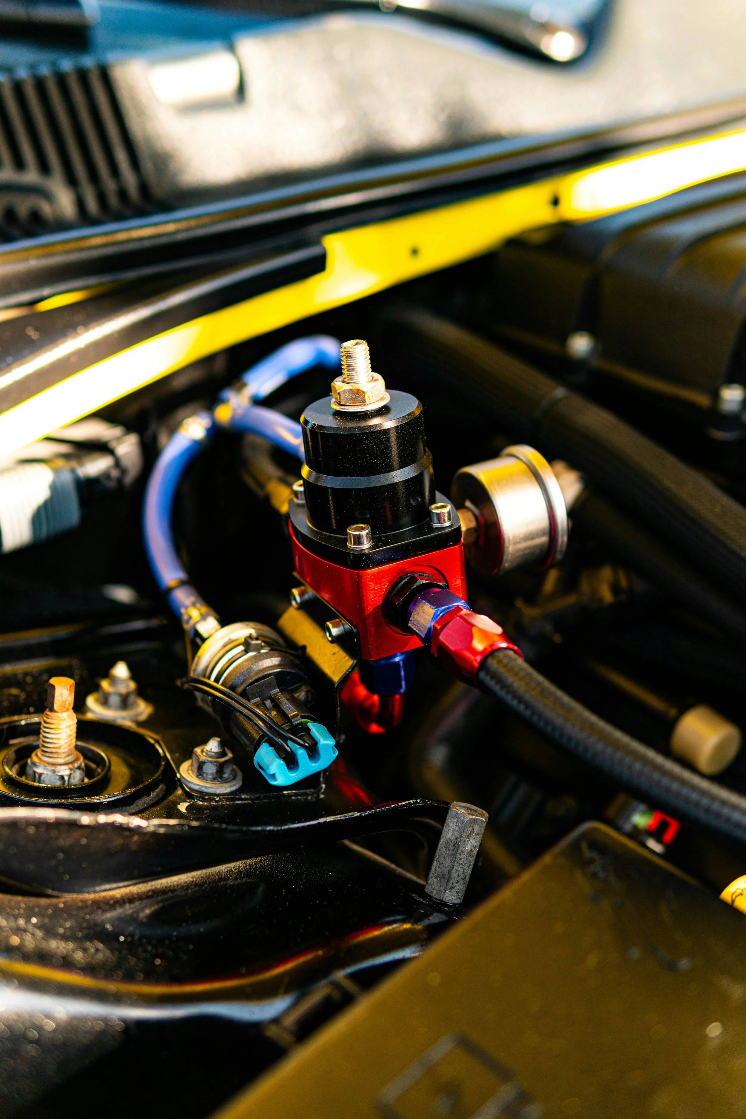 Close-up of a car engine with colorful hoses and metal components.