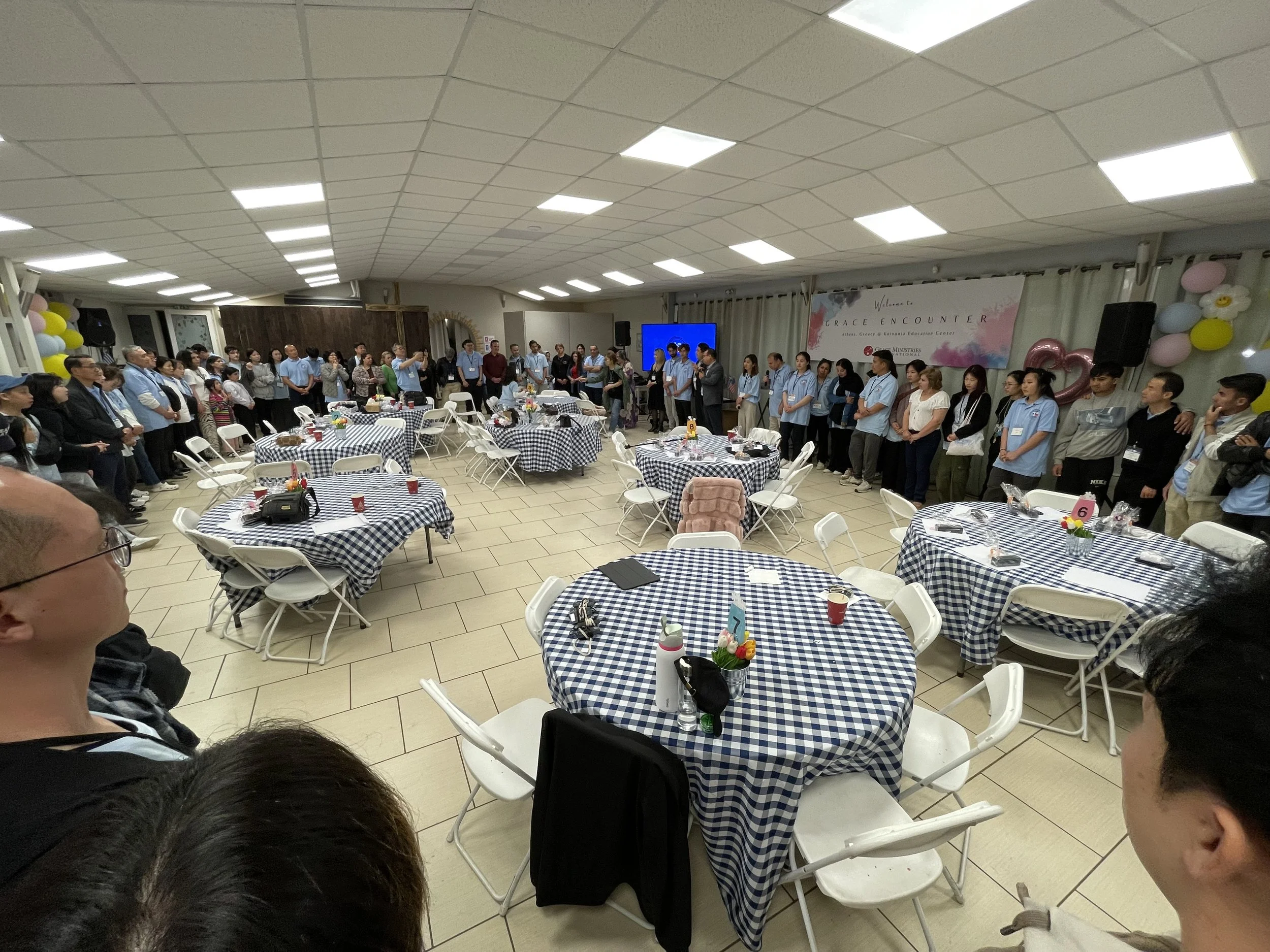 Refugees and international ministry team members worshiping together during Grace Encounter near Athens, Greece.