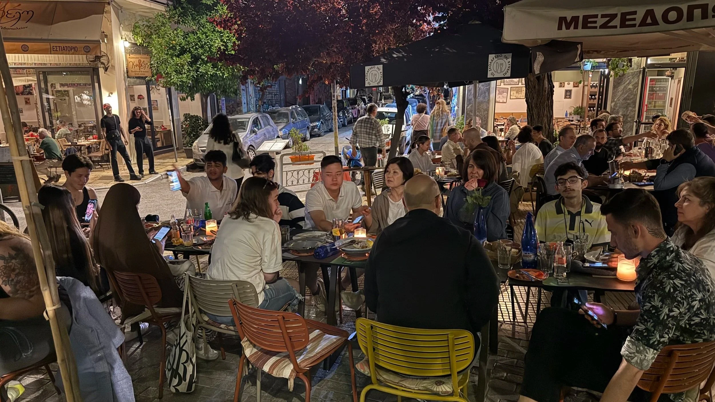 Refugee young adults and ministry volunteers sharing a meal together at a restaurant in Athens.
