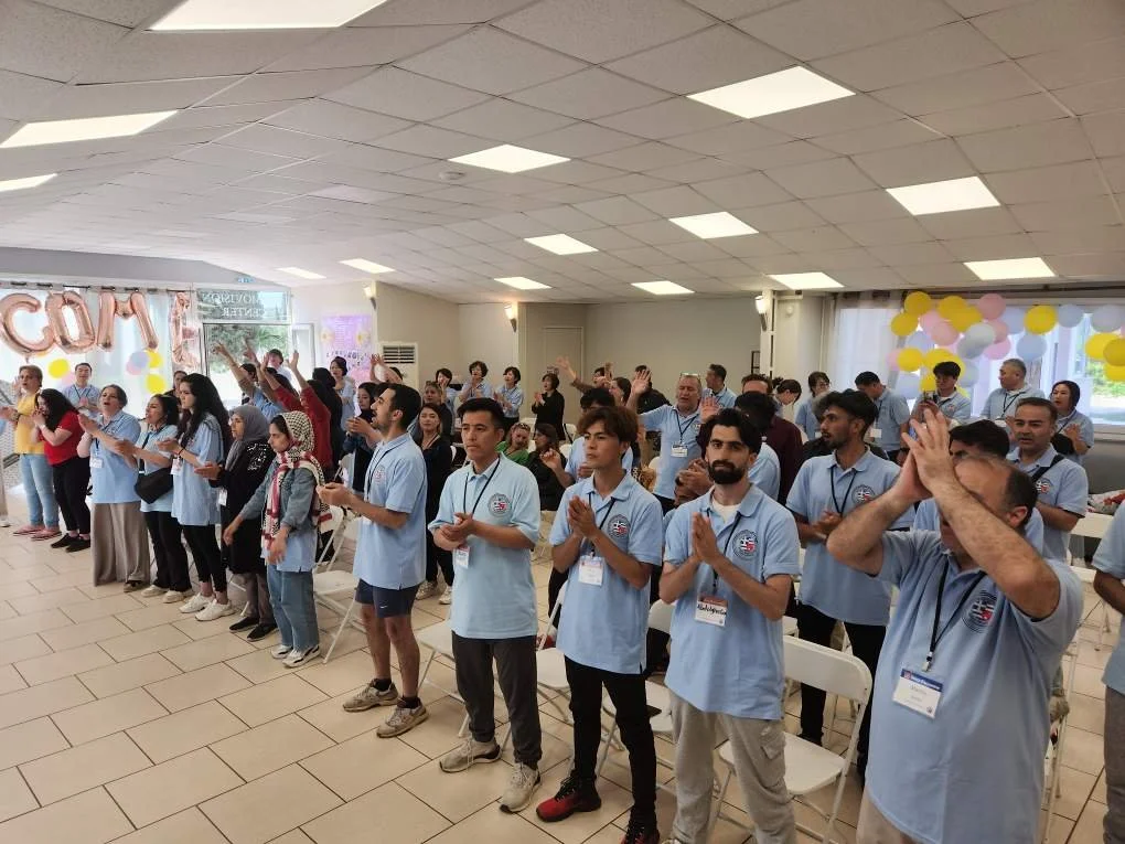 Refugees and international ministry team members worshiping together during Grace Encounter near Athens, Greece.
