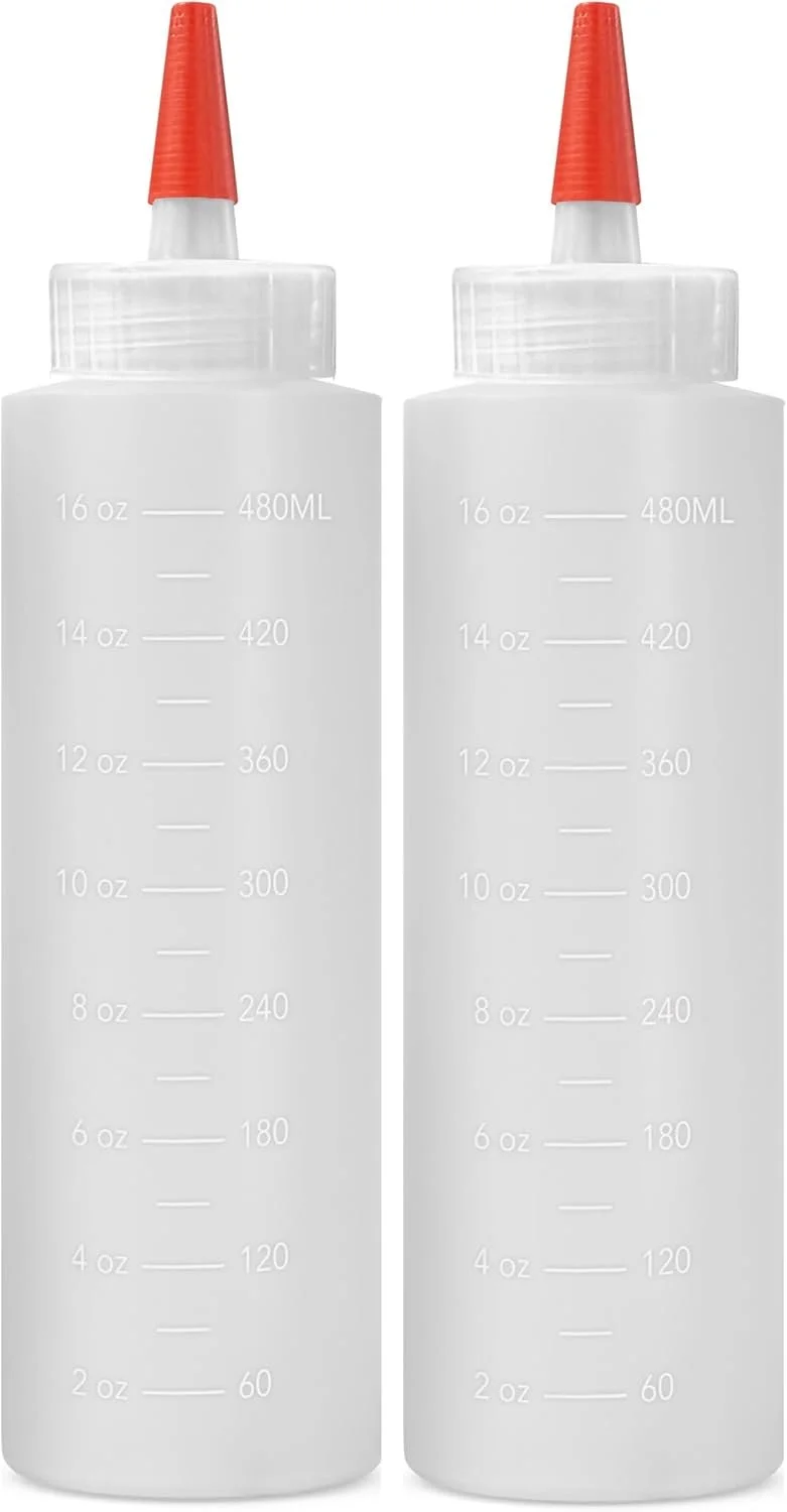 Two empty white squeeze bottles with red nozzles, side by side, on a white background. The bottles have measurement markings in ounces and milliliters.