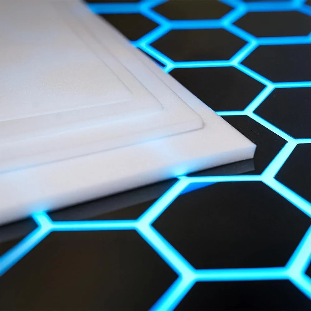 Close-up of a laptop on a black surface with glowing blue hexagon pattern lights.