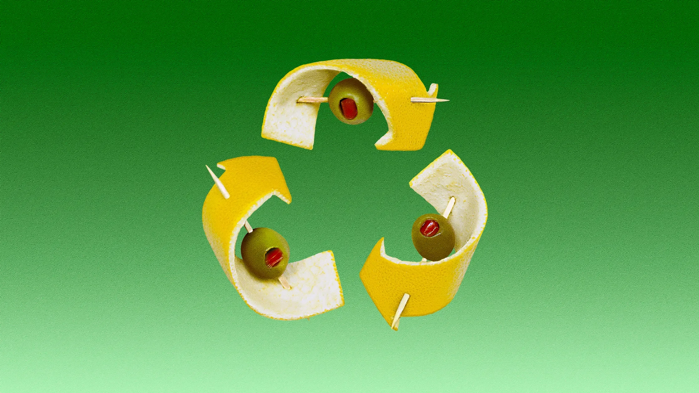 Slices of lemon peel with green olives and red pimiento stuffed inside, arranged in a circle on a green background.