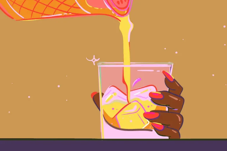 A hand with red painted nails holding a glass as a yellow-orange beverage is poured into it over ice cubes.