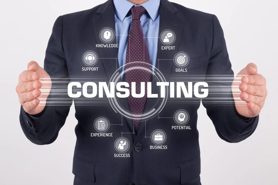 Businessman holding holographic digital interface with the word 'Consulting' and icons representing knowledge, support, experience, success, business, potential, goals, and expert.