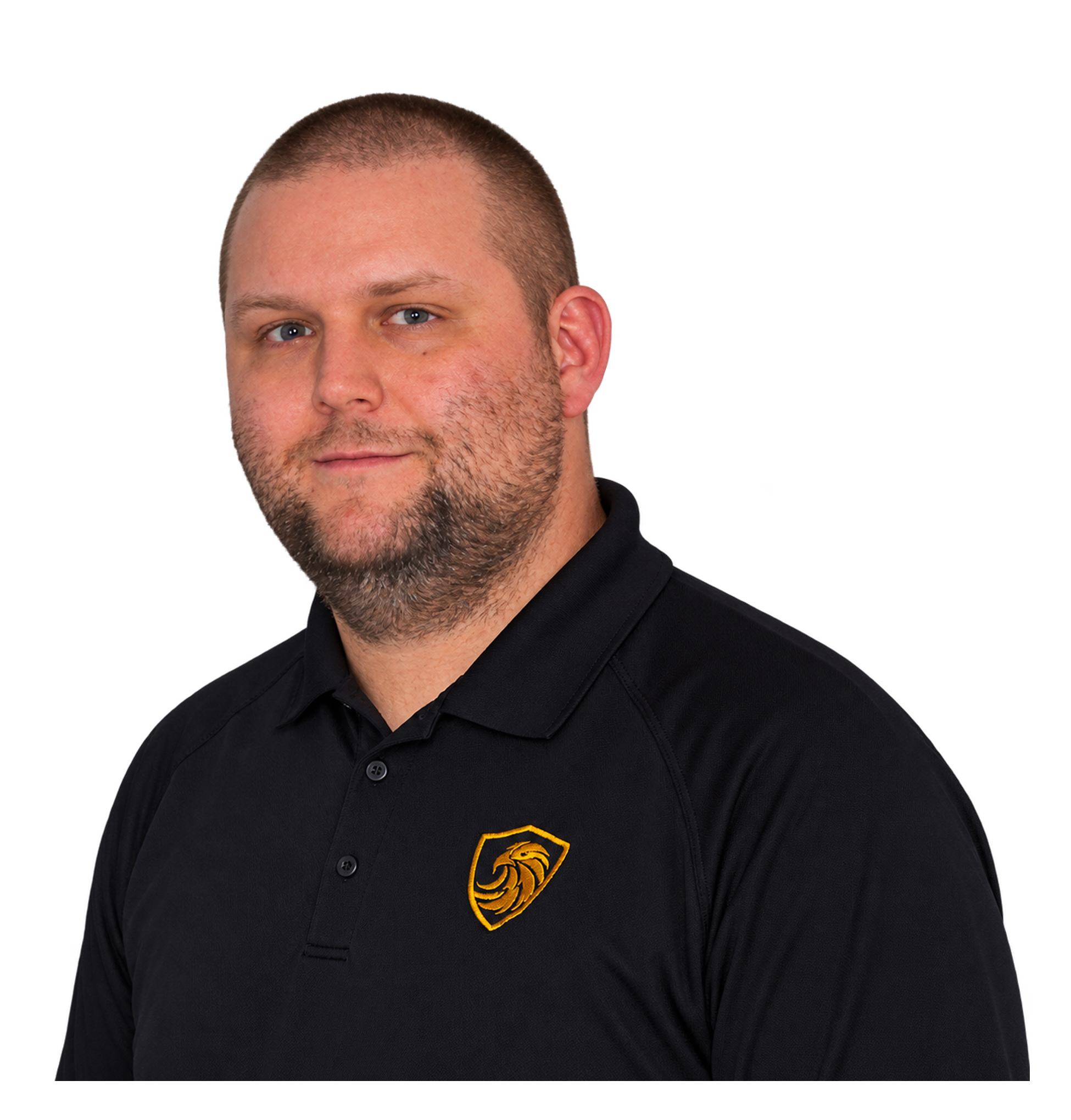 Close-up of a man wearing a black sports jersey with a yellow lion emblem on the chest, with a shaved head and short beard, against a red background.