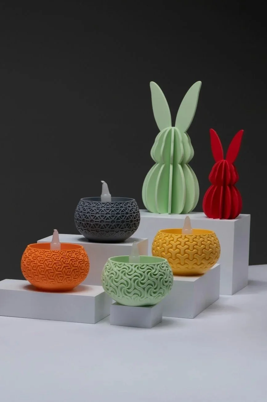 Colorful ceramic bunny and candle holders on white display stands