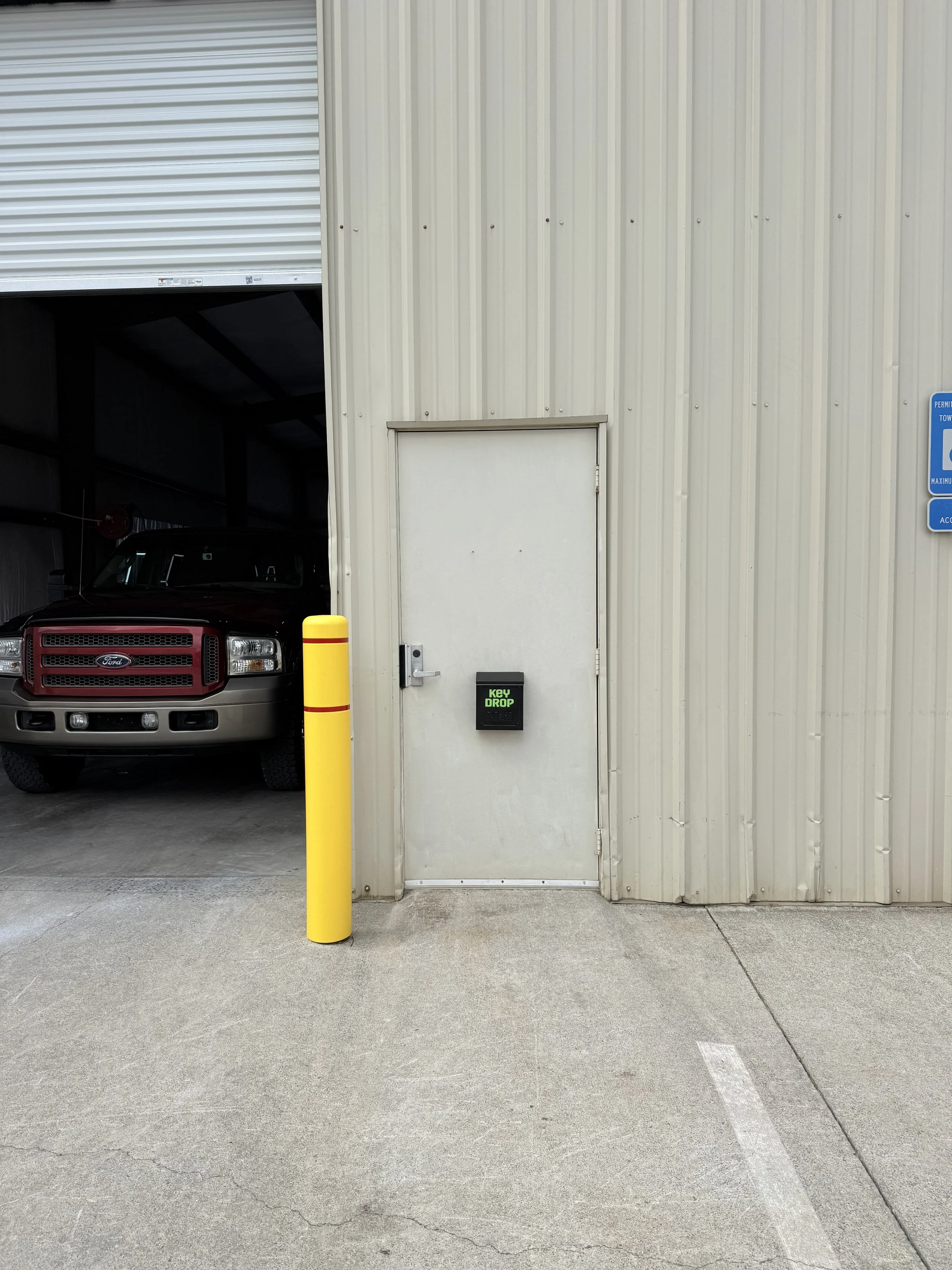 Find the Key Drop box on the shop door, next to the garage bay.