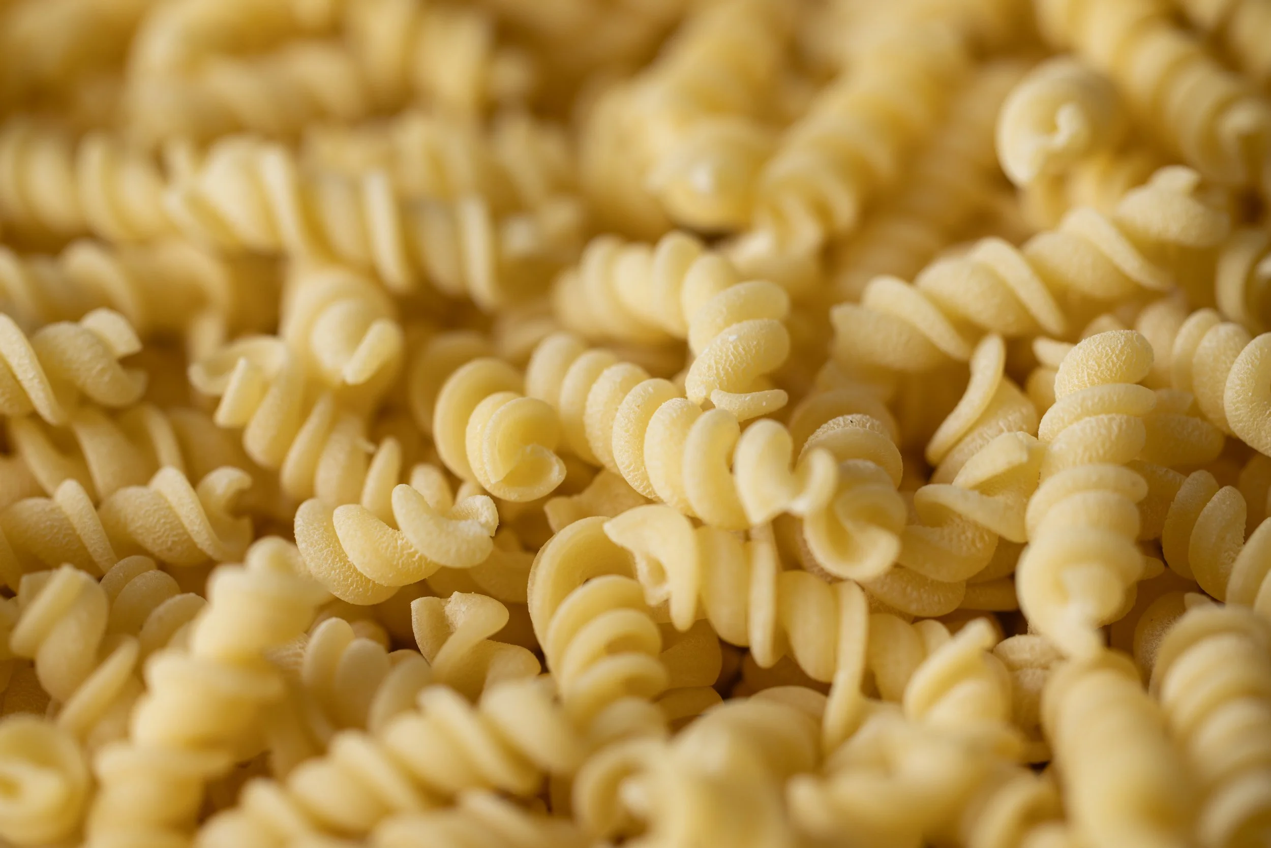 Close-up of uncooked rotini pasta noodles.