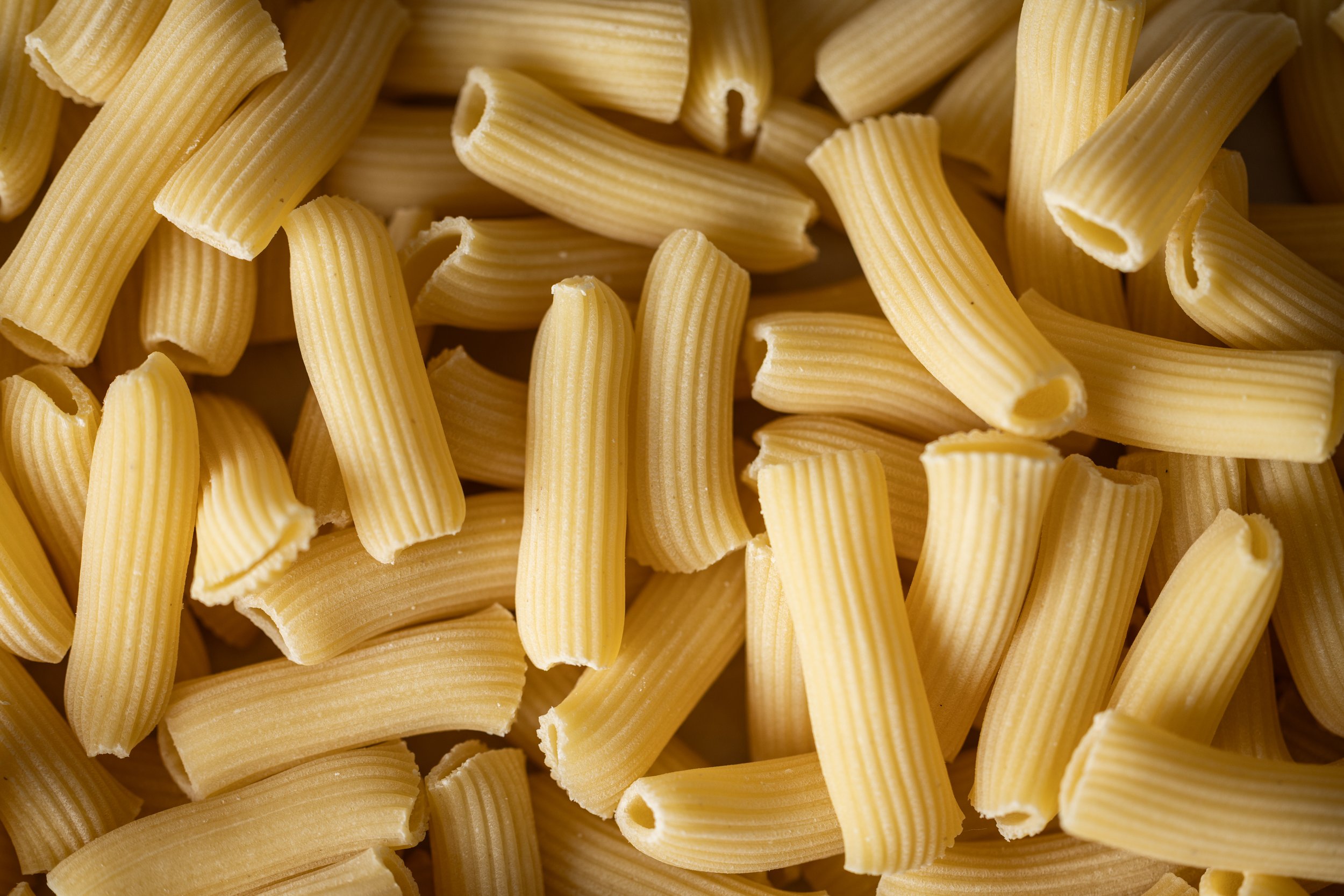Close-up of uncooked rigatoni pasta.