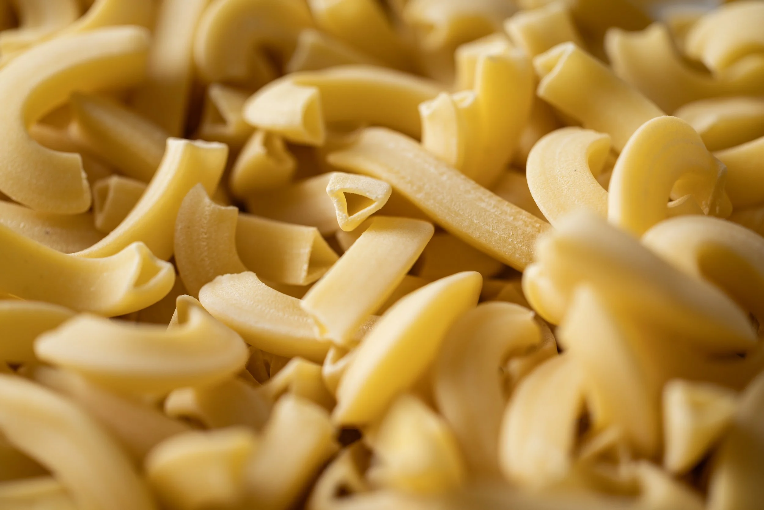 Close-up of uncooked pasta, specifically pasta with a curly or spiral shape.