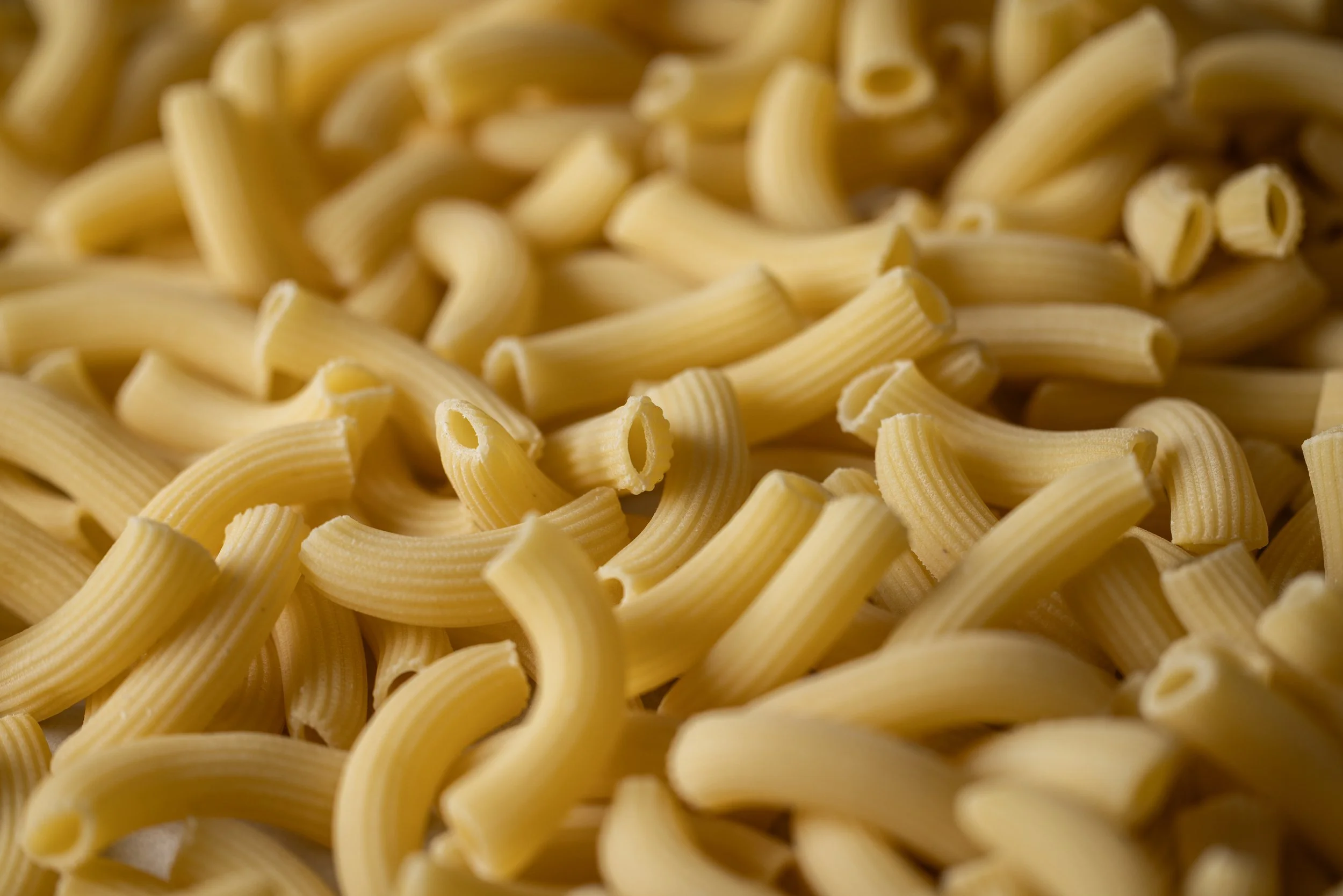 Close-up of uncooked rigatoni pasta.