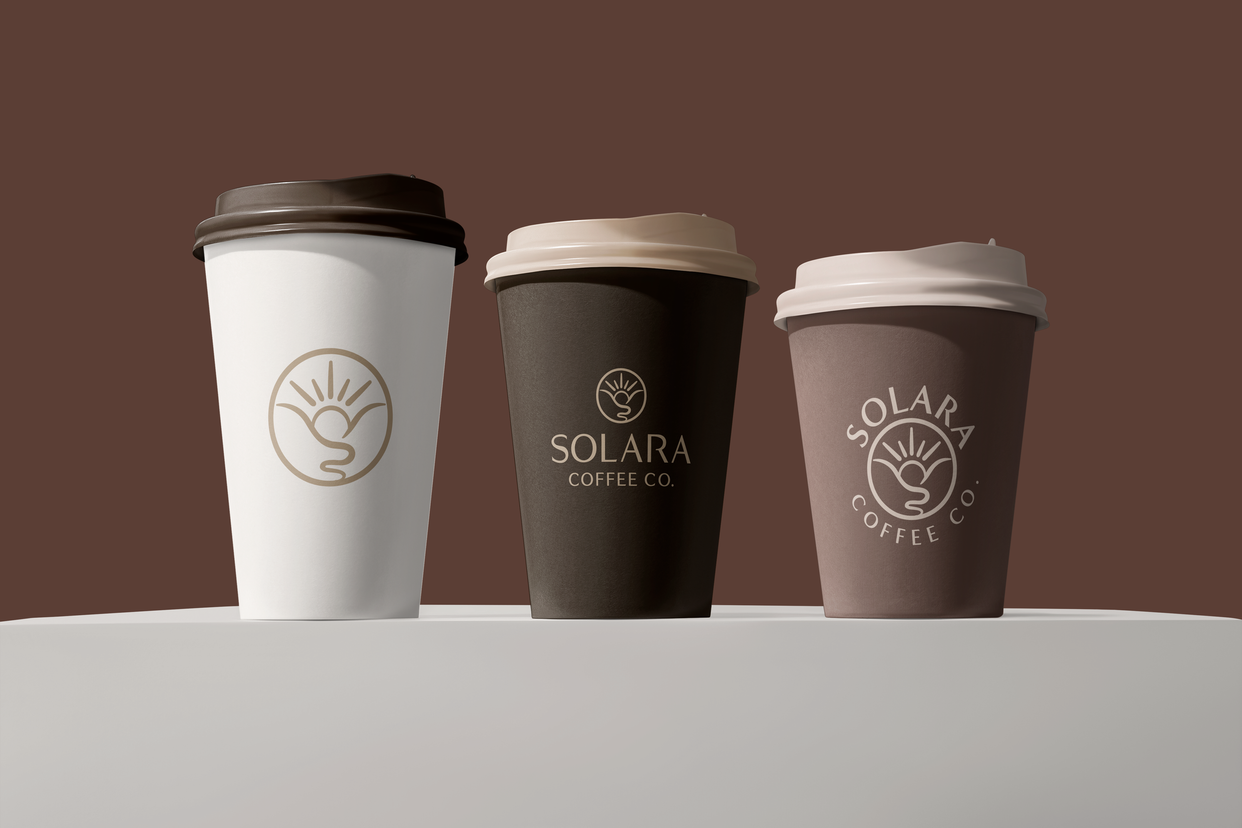 Three to-go coffee cups with different colors and logos from Solara Coffee Co., placed on a white surface against a brown background.