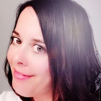 Close-up of a woman with long dark hair smiling at the camera