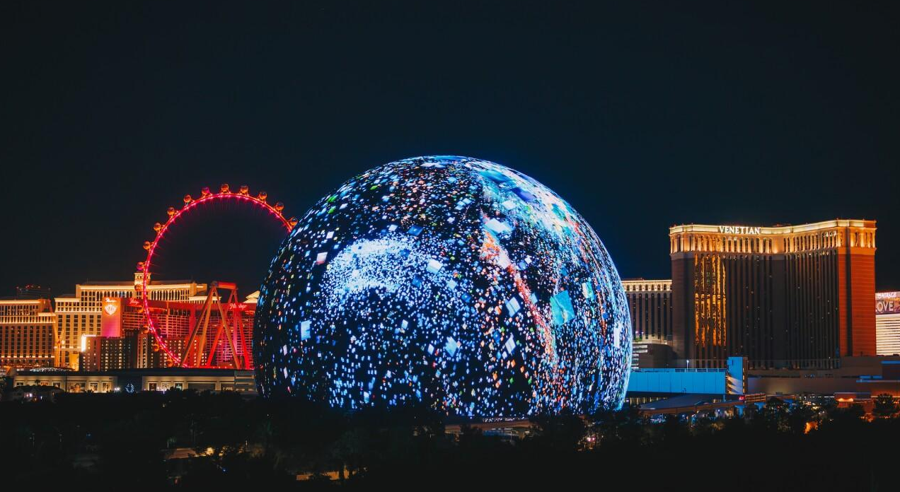 Las Vegas Sphere glowing beside the Las Vegas Strip at night