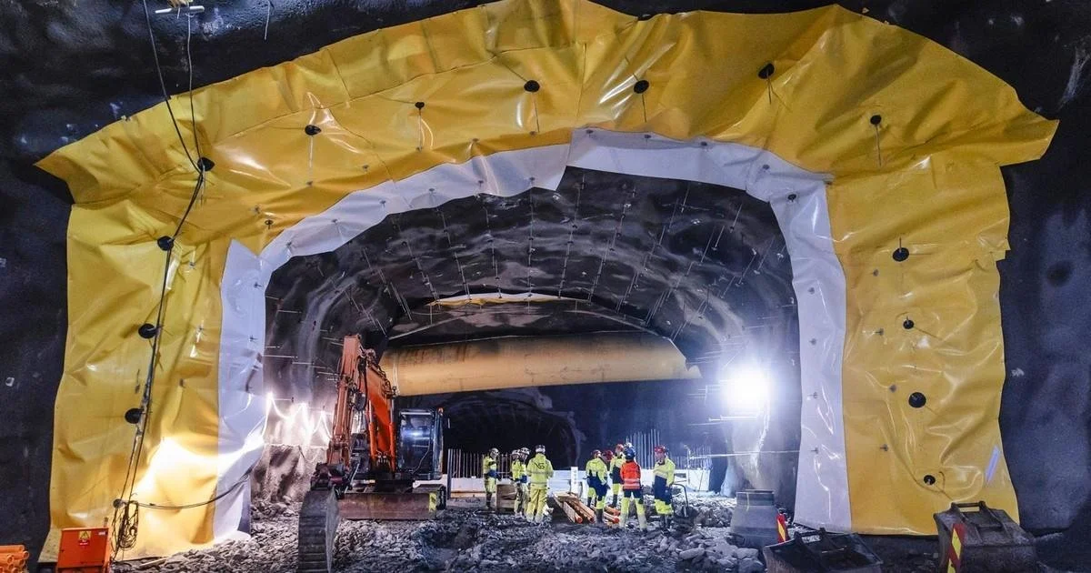 Construction crews and heavy equipment excavating rock inside Norway’s Rogfast road tunnel.