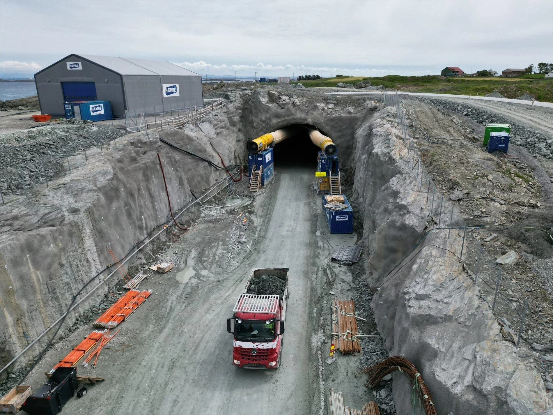 Heavy construction machinery working underground on the E39 Rogfast tunnel project in Norway.