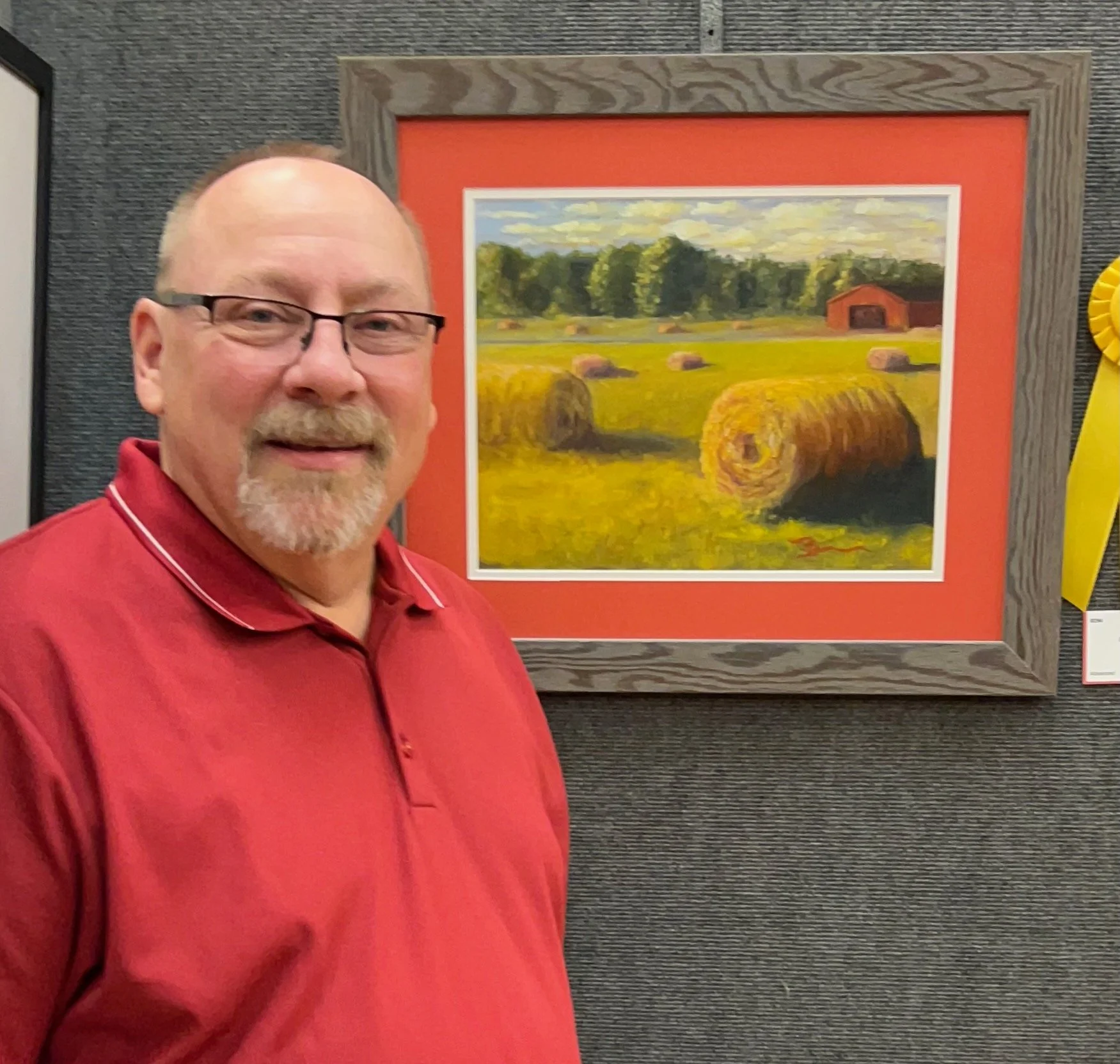 Artist Dale Biscardi standing beside one of his award-winning landscape paintings.