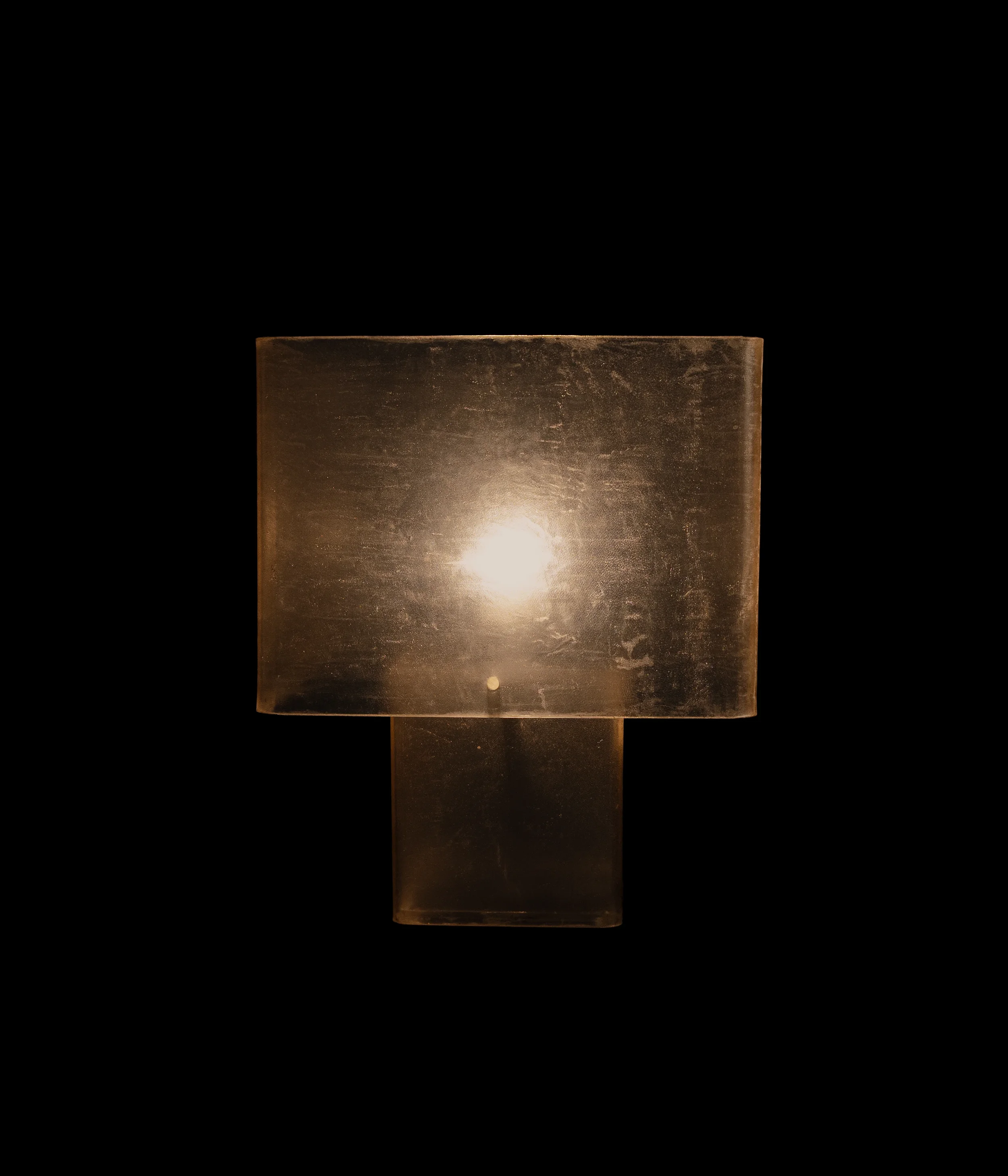 Minimalist sculptural table totem wrapped in hand-stitched raw leather with architectural brass details.