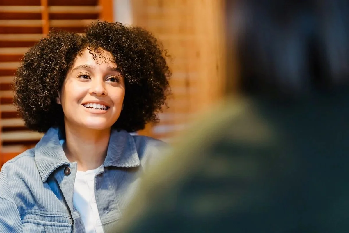 A woman smiling during a conversation with a counselor.