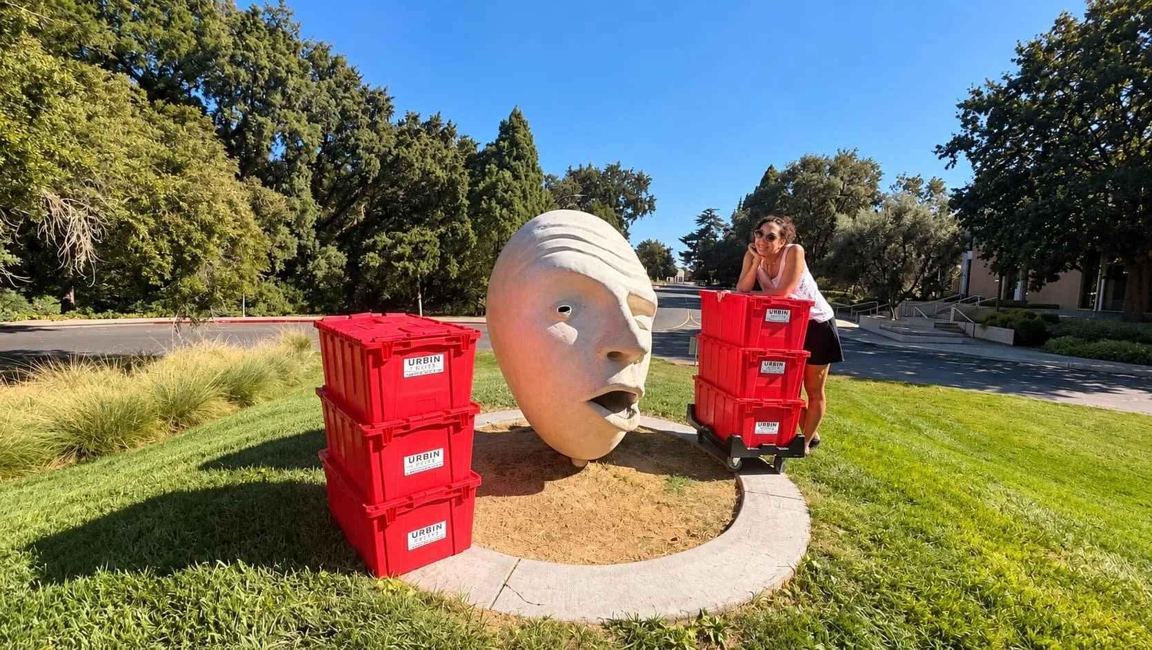 Lady standing near red moving bins in Davis California
