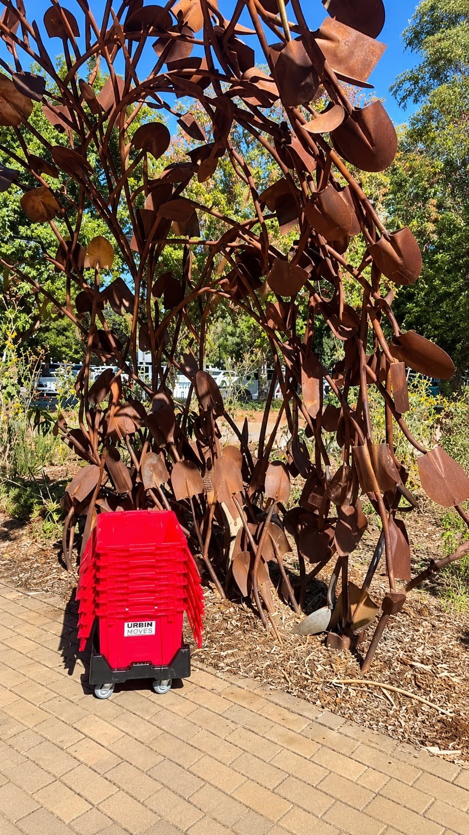 Red moving bins near a metal sculpture Davis California