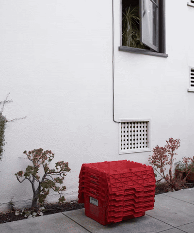 Red moving bins near a building