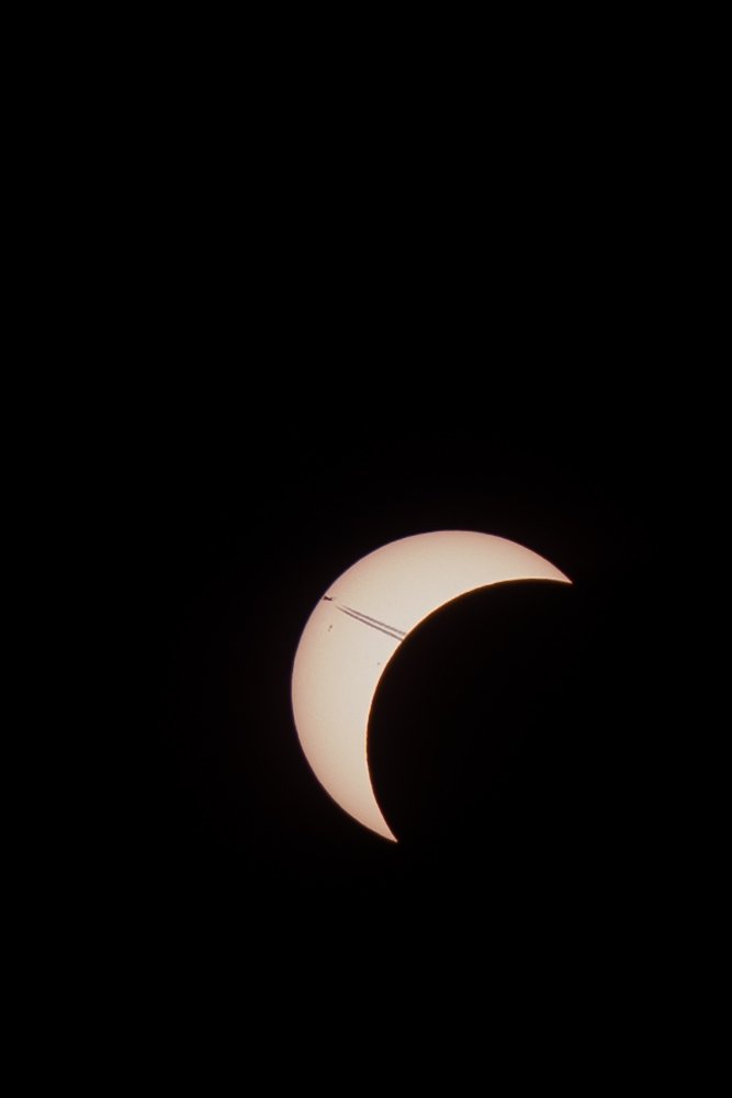 It is 19:57 on August 12th, 2026. An airplane passes over Delft, but no one is looking at it. An eclipse is happening. It slips past the Sun unnoticed, only to be discovered hours later in this photo.