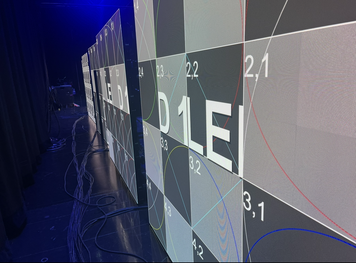 Digital screen with colorful lines and numbers displaying the word 'IDE' in large white letters.