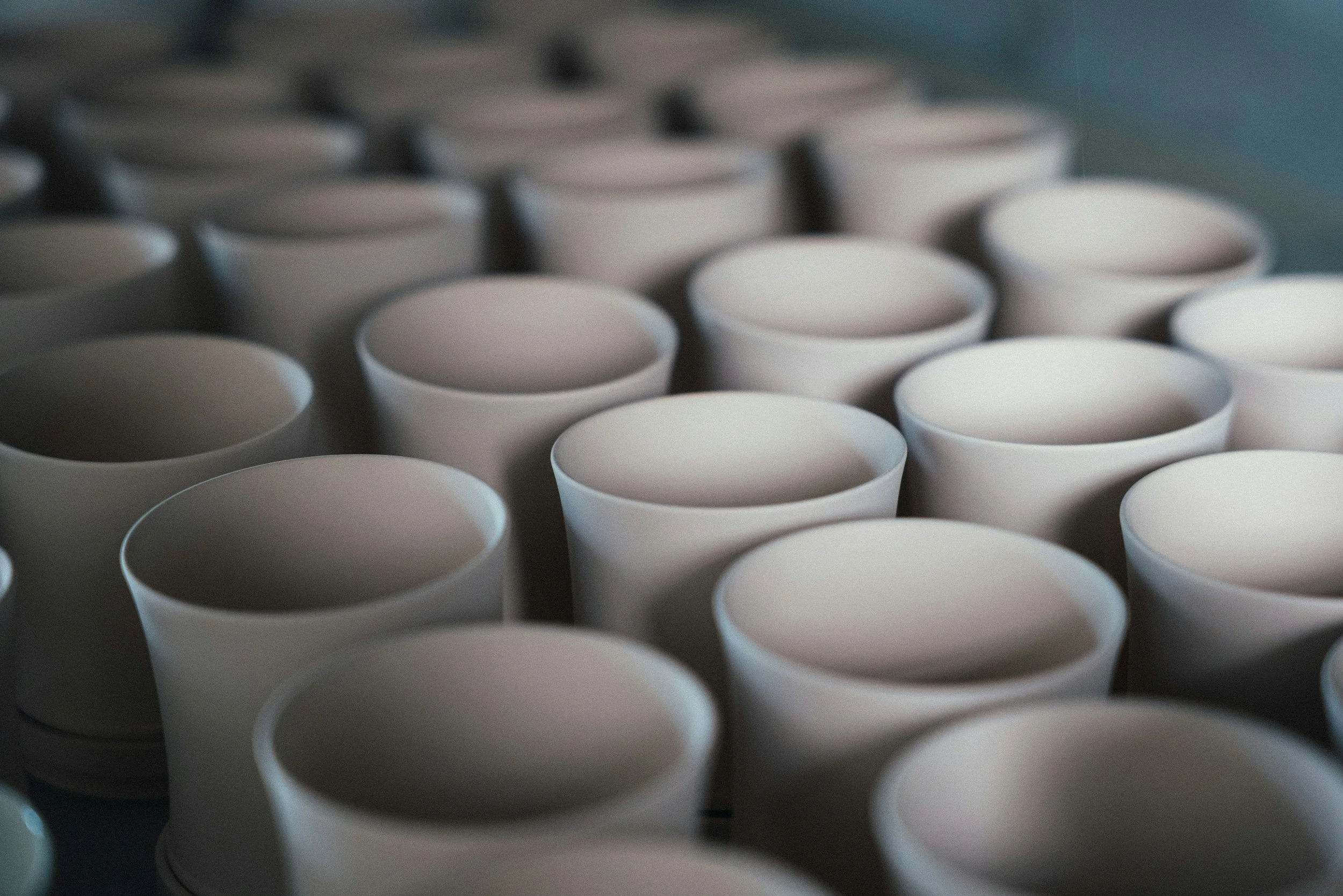 Close-up of numerous white paper cups arranged in rows, likely stacked or prepared for use.
