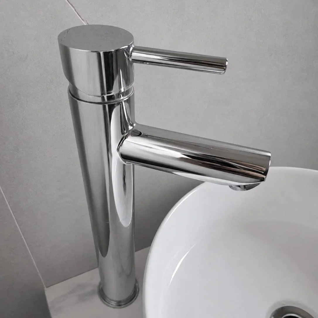 Close-up of a modern chrome bathroom sink faucet with a white ceramic sink basin.
