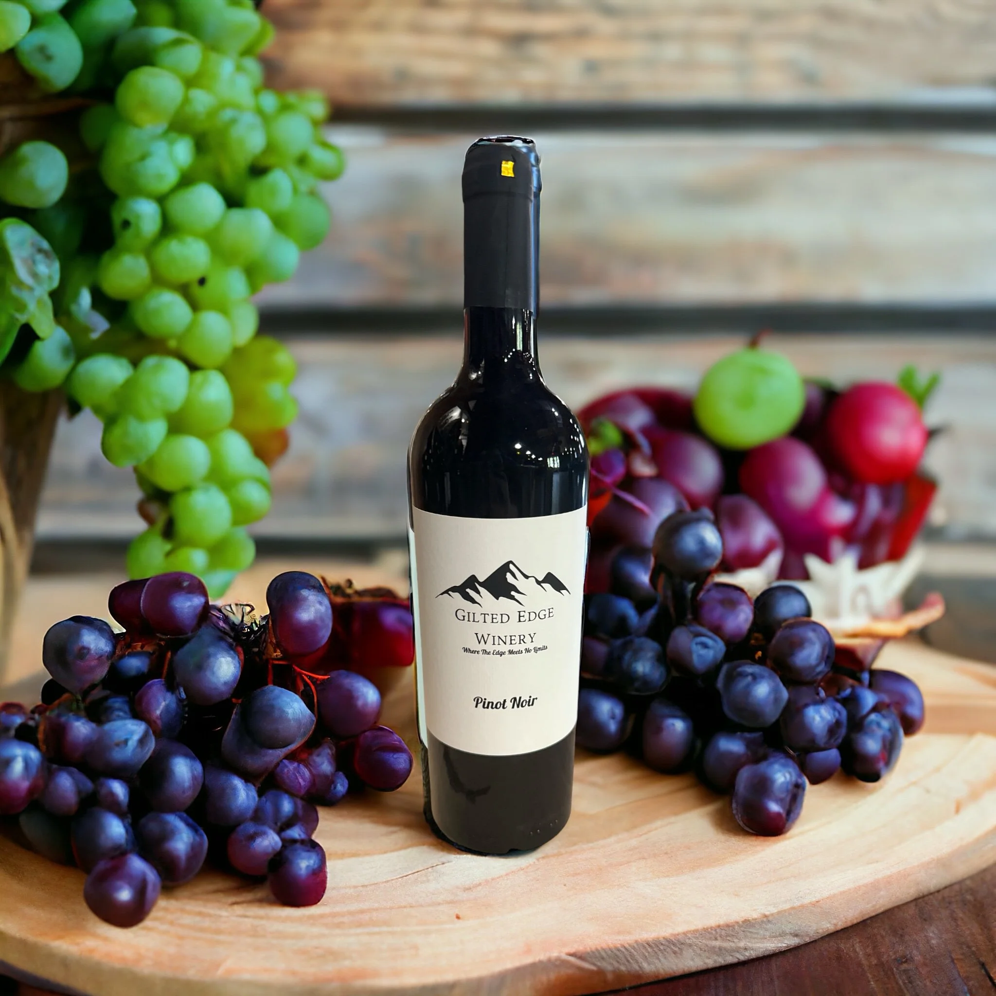 A bottle of wine labeled 'Gilded Edge Winery' surrounded by green and purple grapes on a wooden surface.