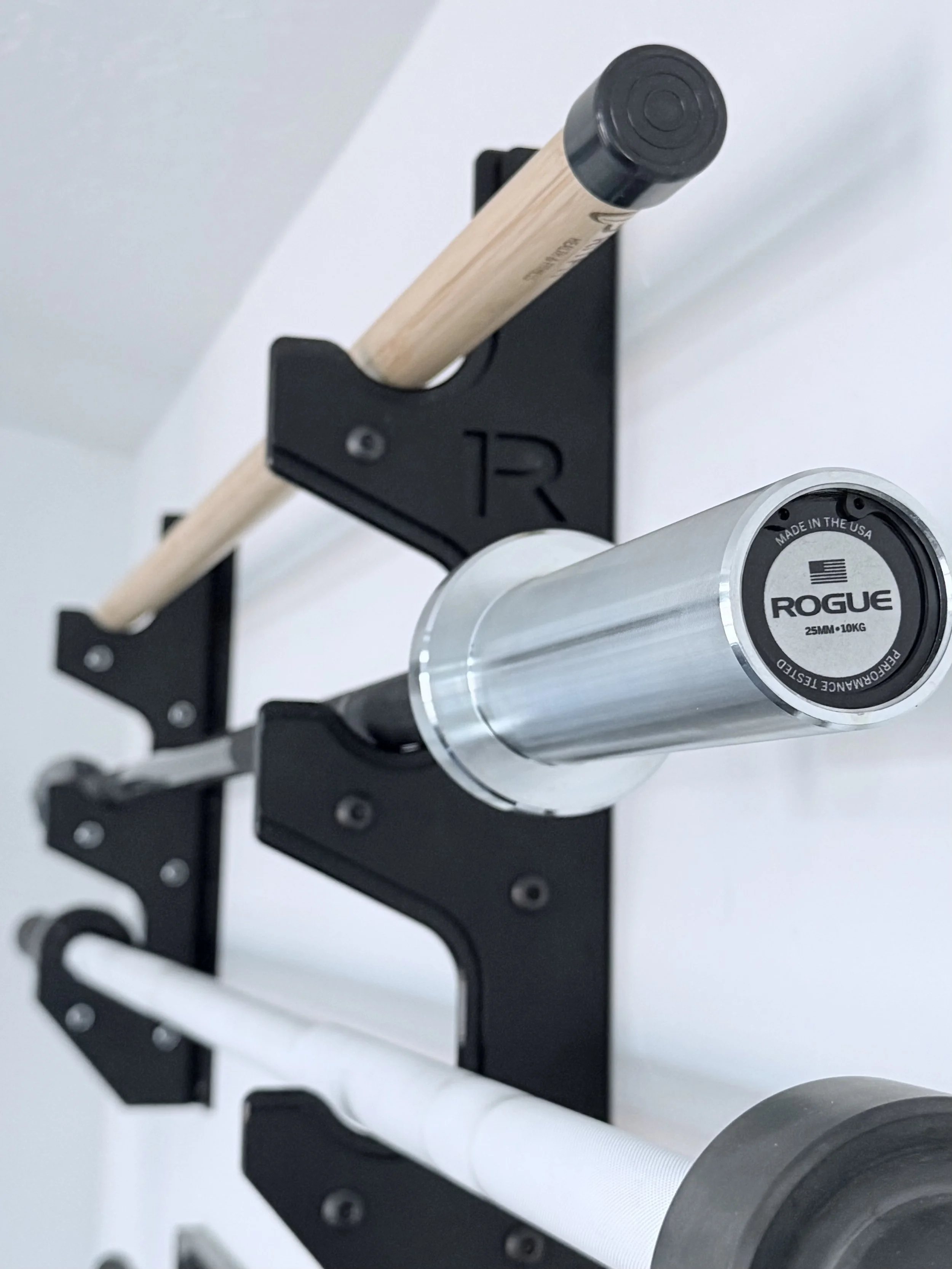 Close-up of a mounted barbell rack on a gym wall.
