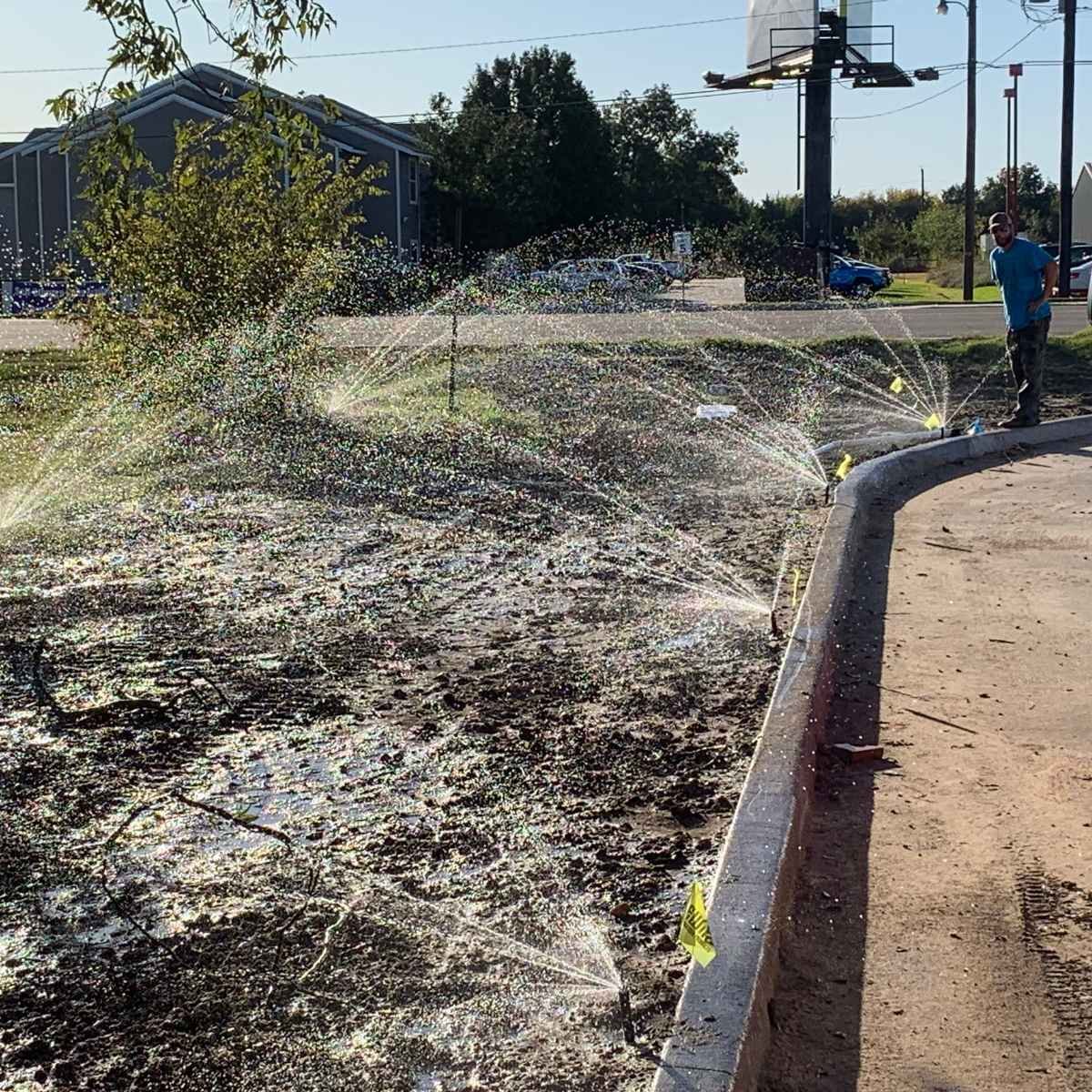 Sprinklers shown running after commercial irrigation system installation.
