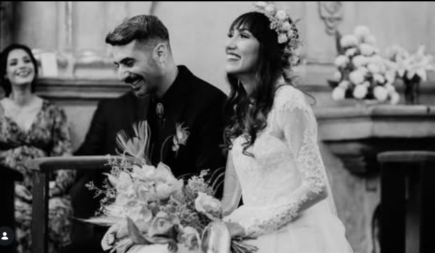 Emotional black and white wedding photograph of a bride and groom sharing a happy moment at the church altar during a destination wedding.