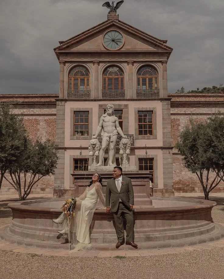 Editorial wedding portrait of a bride and groom at the historic fountain of Hotel Hercules in Queretaro, Mexico.