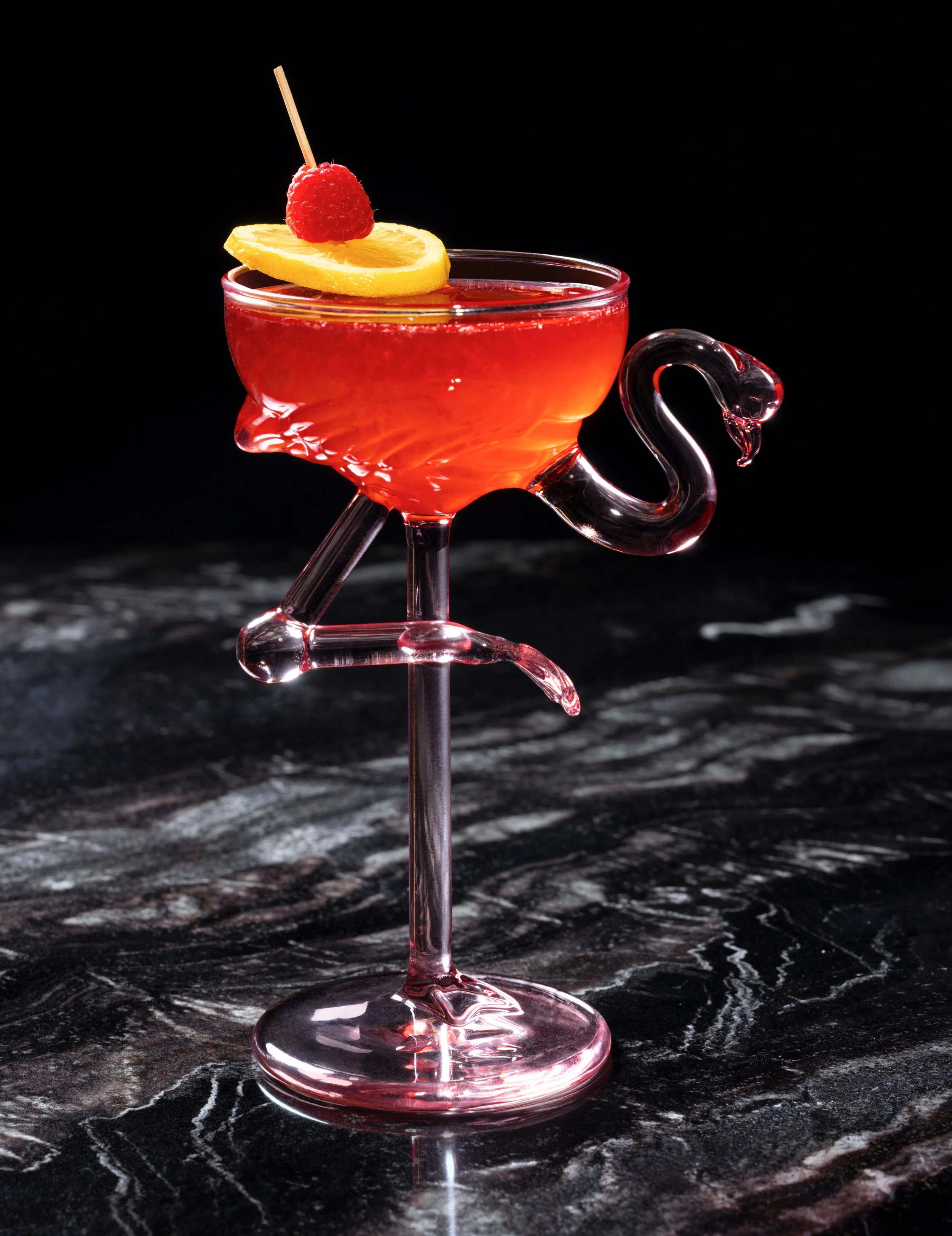 Cocktail served in a flamingo-shaped glass with a raspberry and lemon garnish at Gordon Ramsay Burger, Flamingo Las Vegas, photographed by Michael Rudin
