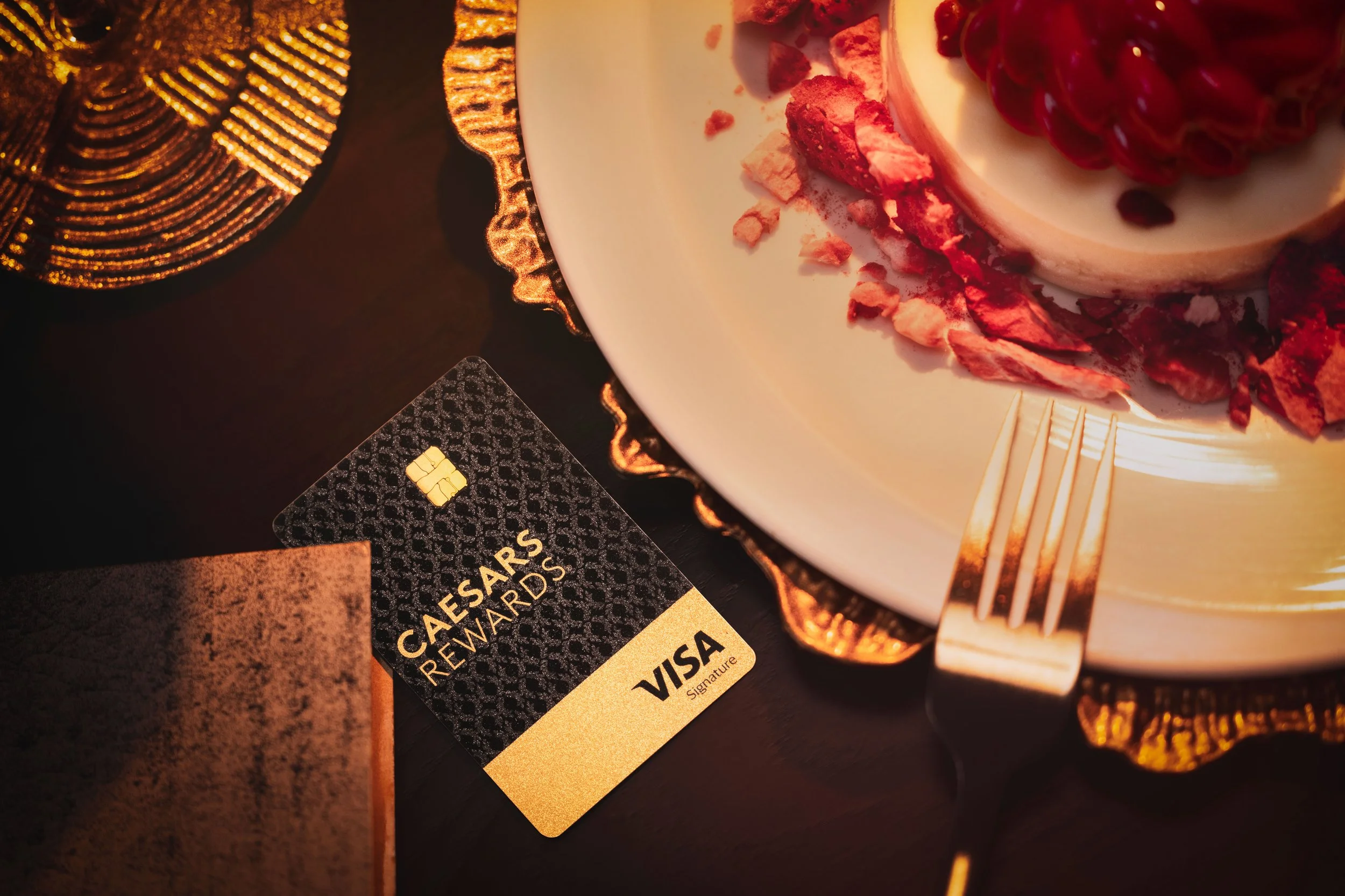 Caesars Rewards Visa card on table with dessert plate, Hell's Kitchen