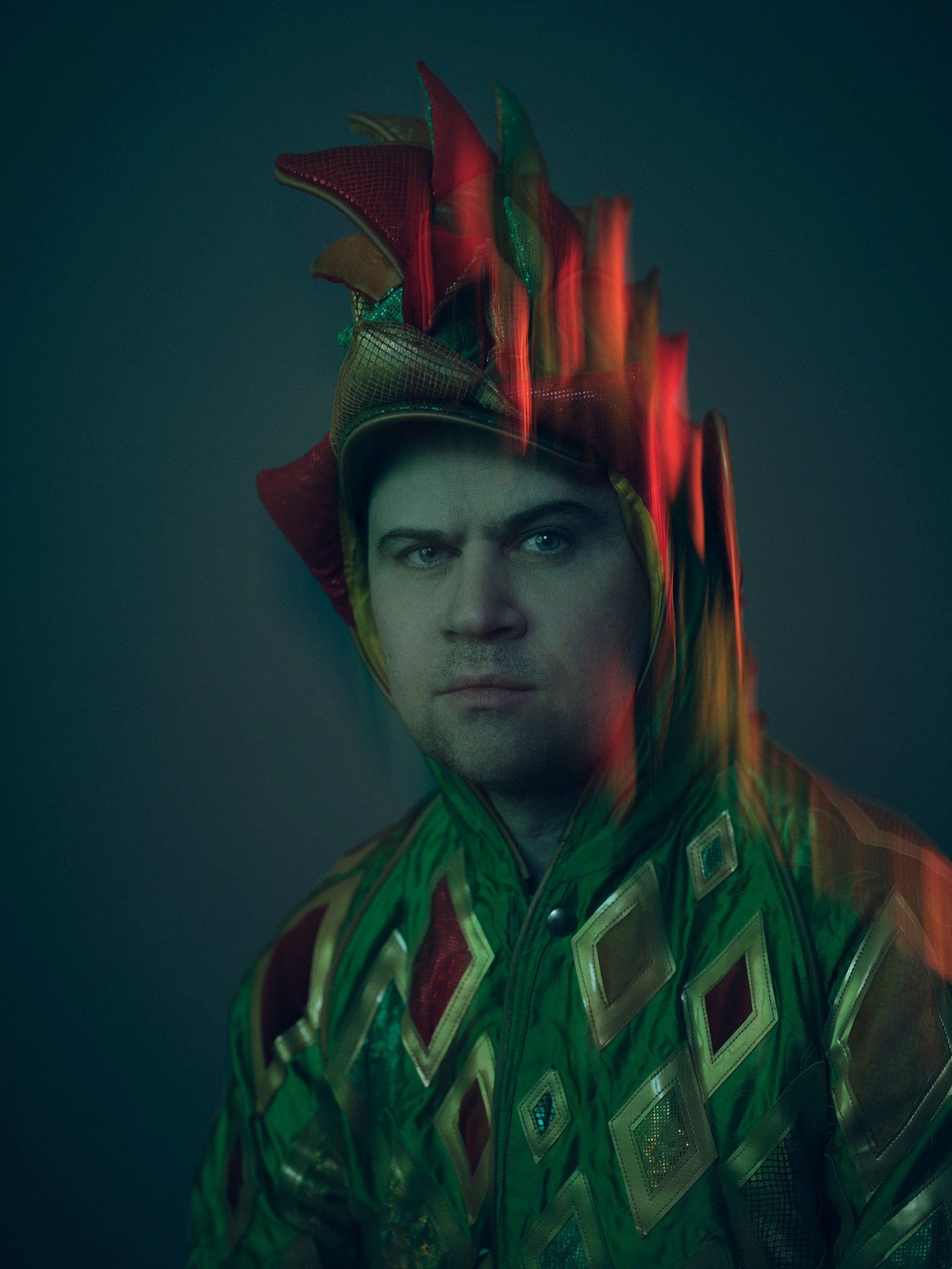 Close personal portrait of performer Piff in jester costume with colored motion blur lighting, photographed by Michael Rudin