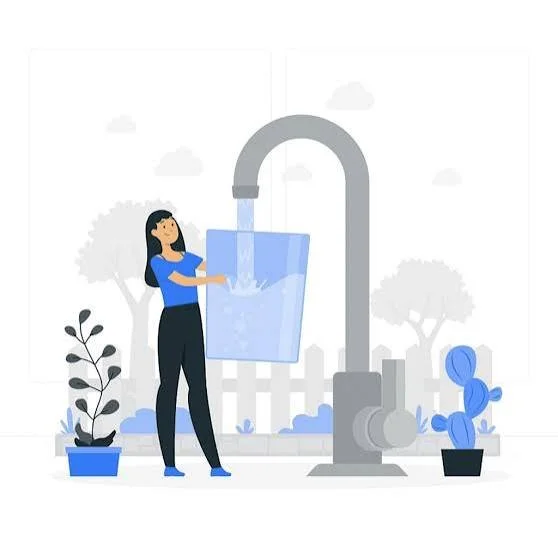 A woman filling a glass with water from a large outdoor faucet, with potted plants and trees in the background.