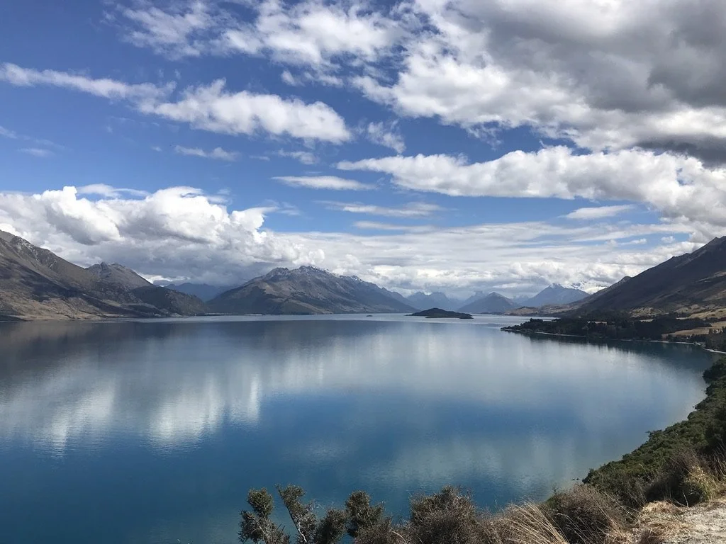 View of a still lake in New Zealand surrounded by mounains
