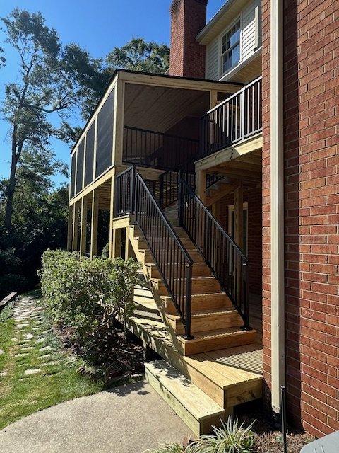 Custom wood deck and stairs and black Trex railings by Prime Home Improvements.