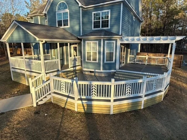 Multi level custom deck with white railings by Prime Home Improvements.