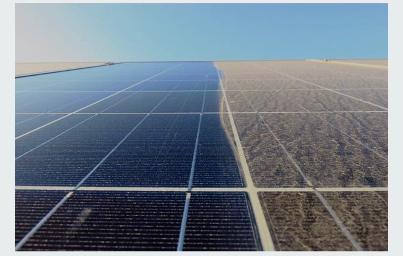 Solar panels installed on a large, flat, sandy area under a clear blue sky.