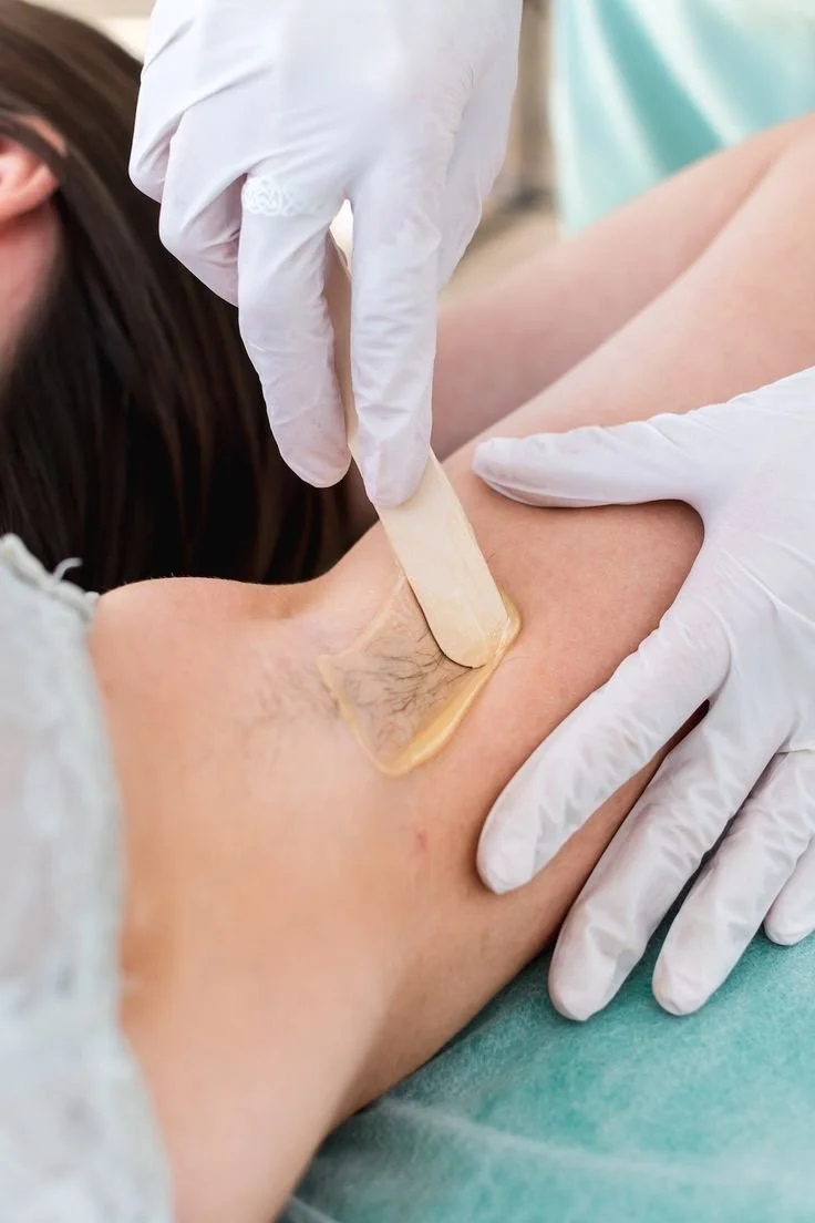 Médico realizando un procedimiento de extracción de sangre o prueba en la vena del brazo de un paciente con guantes blancos.